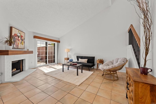 1579 Apache Dr Unit E, Chula Vista, CA 91910 - living room with light tile patterned floors, a textured ceiling, a fireplace, and high vaulted ceiling