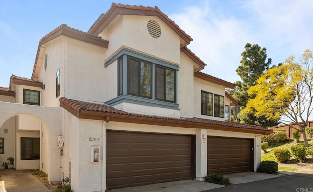 1579 Apache Dr Unit E, Chula Vista, CA 91910 - mediterranean / spanish house featuring a tile roof, a garage, stucco siding, and asphalt driveway
