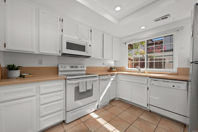 1579 Apache Dr Unit E, Chula Vista, CA 91910 - kitchen with white appliances, white cabinetry, recessed lighting, light tile patterned floors, and light countertops