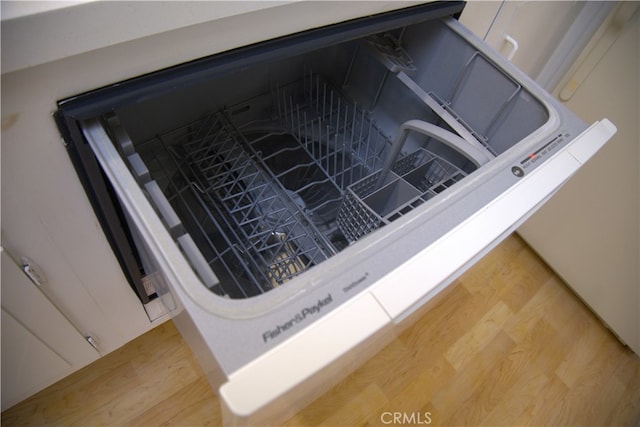 kitchen view of light wood-style floors and dishwashing machine