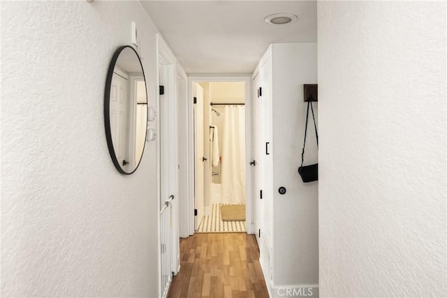 1100 Euclid Ave Unit 103, Long Beach, CA 90804 - hallway with light wood-style flooring, a textured wall, and baseboards