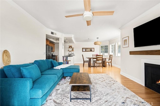 1100 Euclid Ave Unit 103, Long Beach, CA 90804 - living area with a ceiling fan, crown molding, a lit fireplace, light wood finished floors, and baseboards