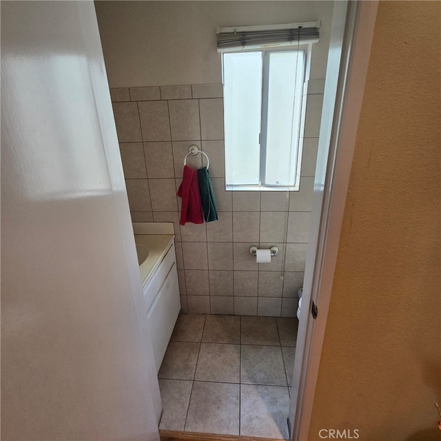 full bath featuring toilet, a washtub, tile walls, and tile patterned flooring