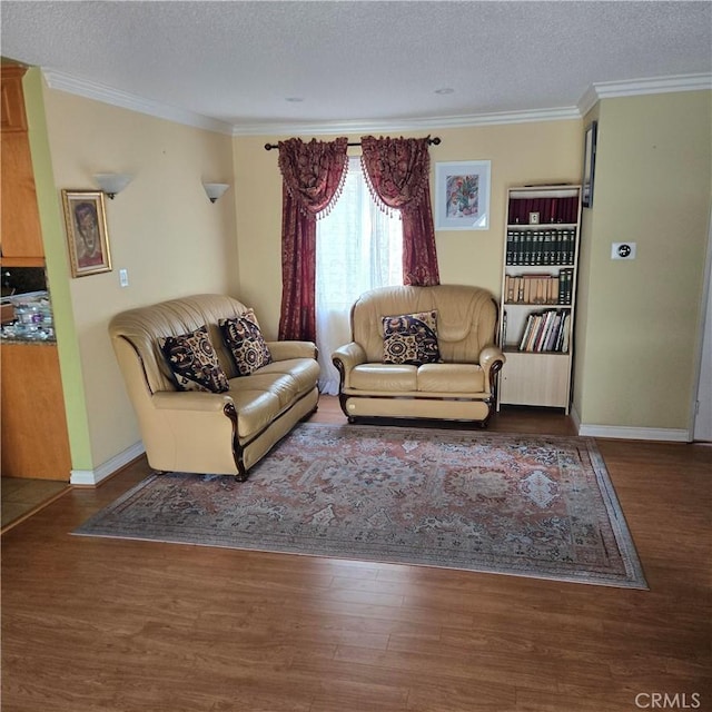 living area with ornamental molding, a textured ceiling, and wood finished floors