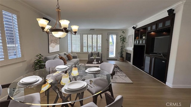 1731 Via Ln, Loma, Chino Hills, CA 91709 - dining area with a chandelier, wood finished floors, baseboards, ornamental molding, and a fireplace