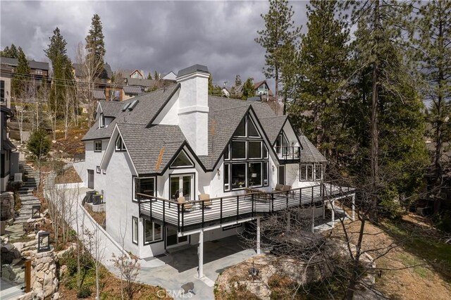729 Brentwood Dr, Lake Arrowhead, CA 92352 - back of property with a patio area, a chimney, stucco siding, french doors, and roof with shingles