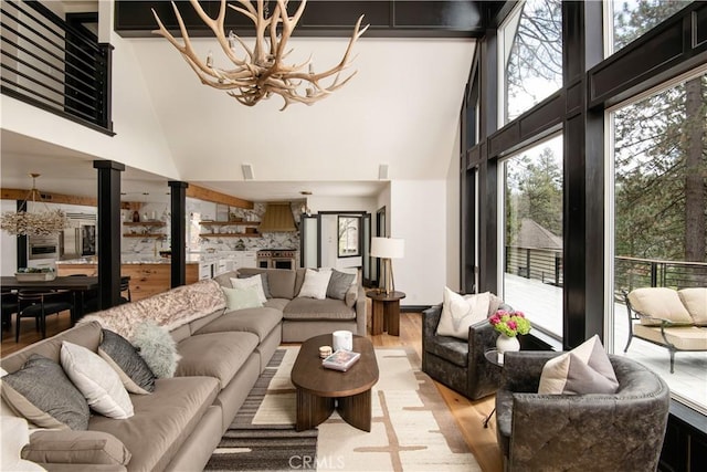 729 Brentwood Dr, Lake Arrowhead, CA 92352 - living room with a chandelier, a towering ceiling, visible vents, and light wood-style flooring