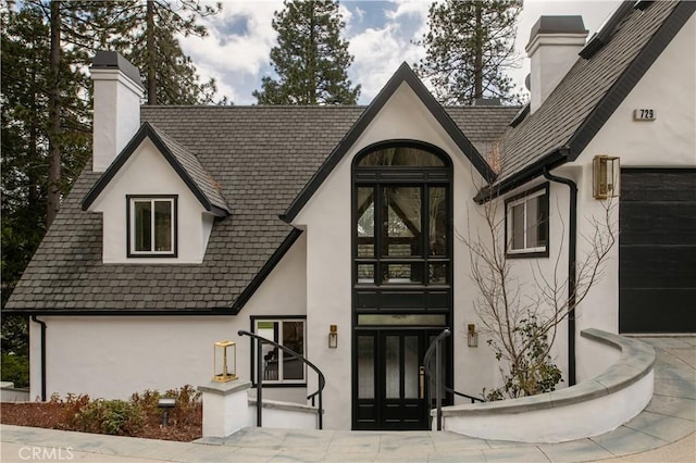 729 Brentwood Dr, Lake Arrowhead, CA 92352 - property entrance with stucco siding and a chimney