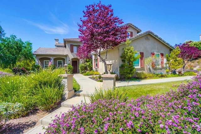 view of front of house with a chimney and stucco siding