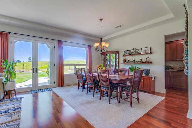 dining room with french doors, visible vents, a notable chandelier, and dark wood-style flooring