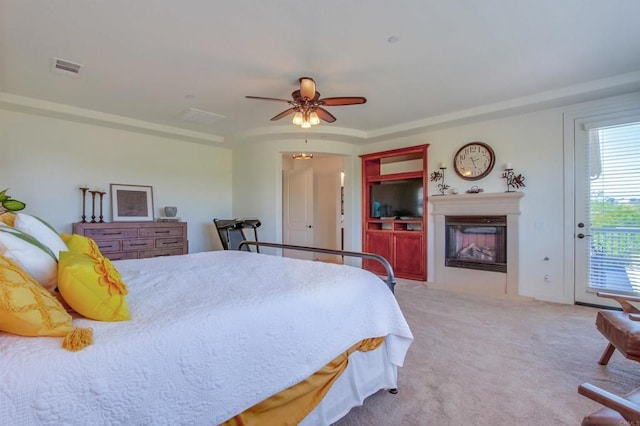 bedroom with a glass covered fireplace, ceiling fan, carpet flooring, and access to outside