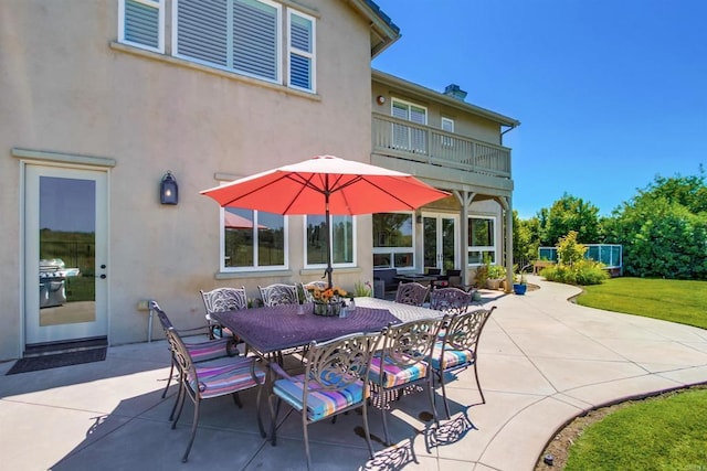 view of patio with outdoor dining space and a balcony