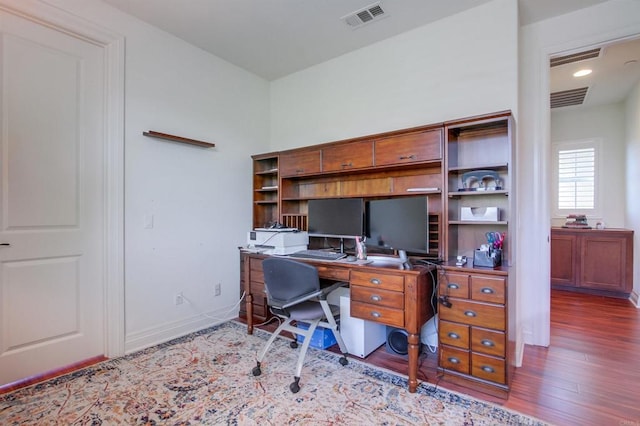 office area with baseboards, wood finished floors, and visible vents