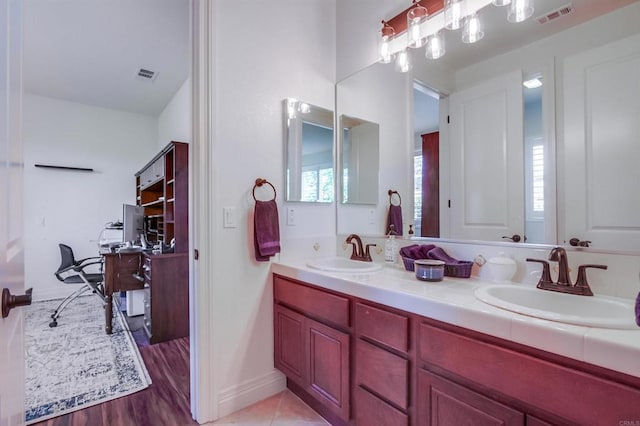 bathroom featuring a sink, visible vents, and double vanity