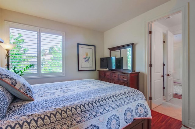 bedroom featuring wood finished floors and multiple windows