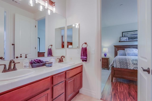 full bathroom featuring double vanity, ensuite bathroom, and a sink