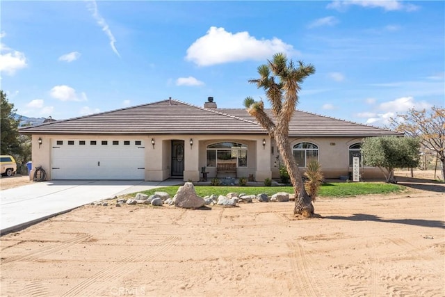view of front of property featuring concrete driveway, stucco siding, a tiled roof, and a garage
