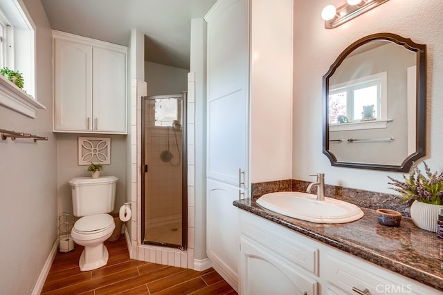 bathroom with toilet, a shower stall, vanity, and wood tiled floor