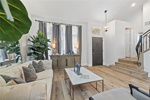 living area with stairs, light wood-type flooring, visible vents, recessed lighting, and baseboards