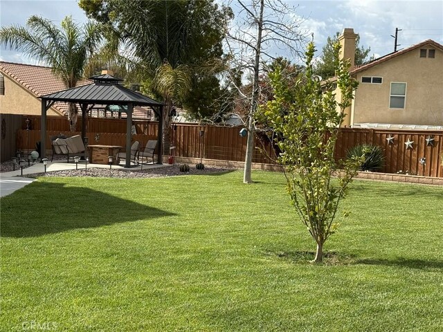 view of yard featuring a patio, a gazebo, and a fenced backyard