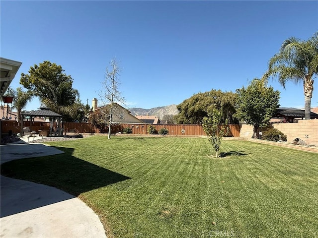 view of yard with a gazebo, a patio area, a mountain view, and a fenced backyard