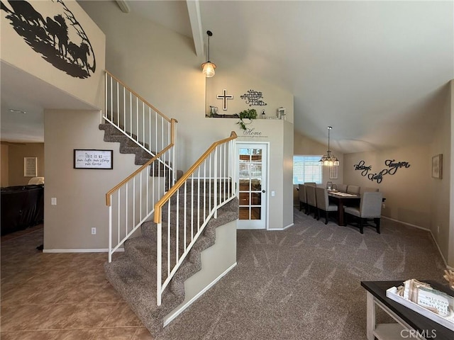 stairway featuring high vaulted ceiling and baseboards