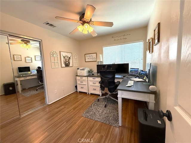 office with baseboards, visible vents, wood finished floors, and ceiling fan