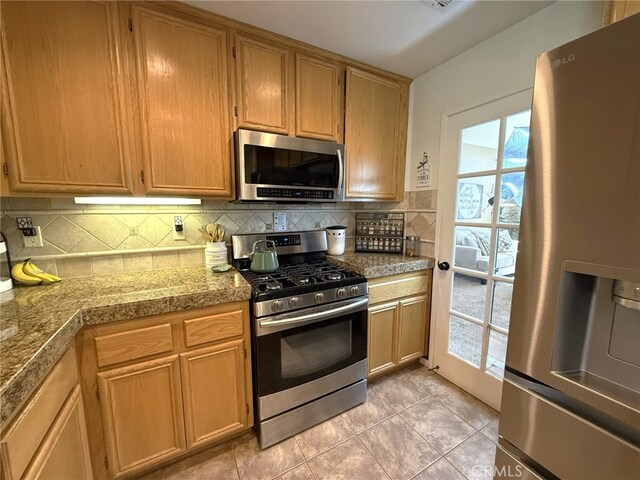 kitchen with light tile patterned flooring, backsplash, tile countertops, and appliances with stainless steel finishes