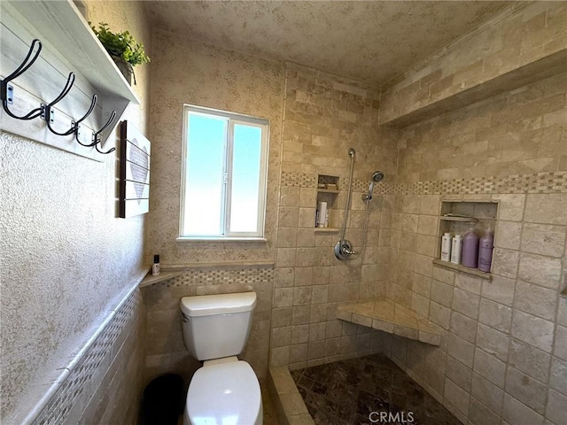 full bath featuring toilet and a tile shower