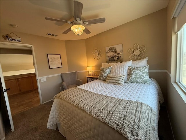 carpeted bedroom with visible vents, a ceiling fan, and baseboards