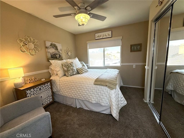 carpeted bedroom featuring a closet, multiple windows, ceiling fan, and baseboards
