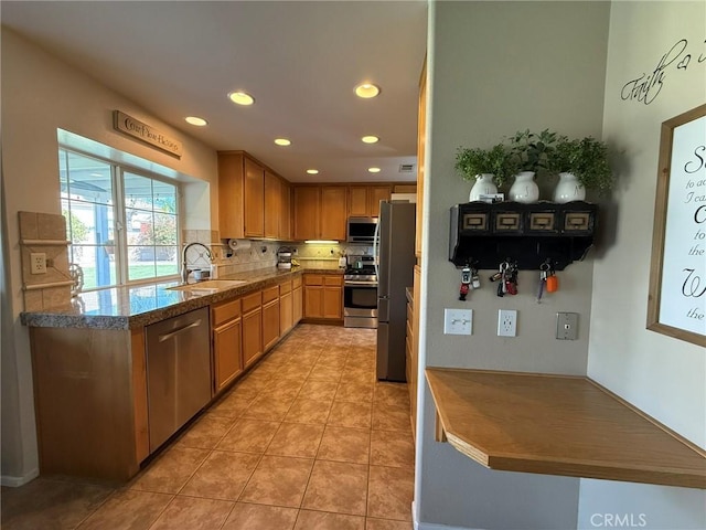 kitchen with light tile patterned floors, a sink, appliances with stainless steel finishes, recessed lighting, and backsplash