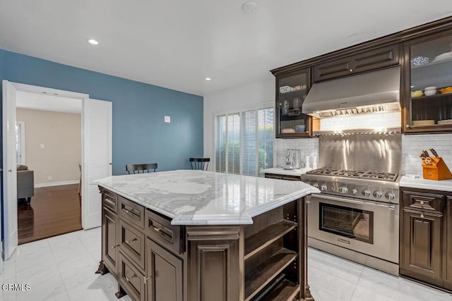 625 S Orange Grove Blvd Unit 3, Pasadena, CA 91105 - kitchen featuring dark brown cabinetry, tasteful backsplash, a kitchen island, under cabinet range hood, and high end stainless steel range oven