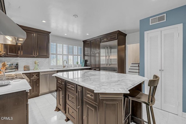 625 S Orange Grove Blvd Unit 3, Pasadena, CA 91105 - kitchen featuring dark brown cabinetry, visible vents, wall chimney exhaust hood, stainless steel appliances, and a sink