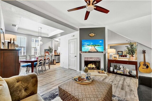 98 Hinterland Way, Ladera Ranch, CA 92694 - living room featuring a lit fireplace, a ceiling fan, crown molding, visible vents, and wood finished floors