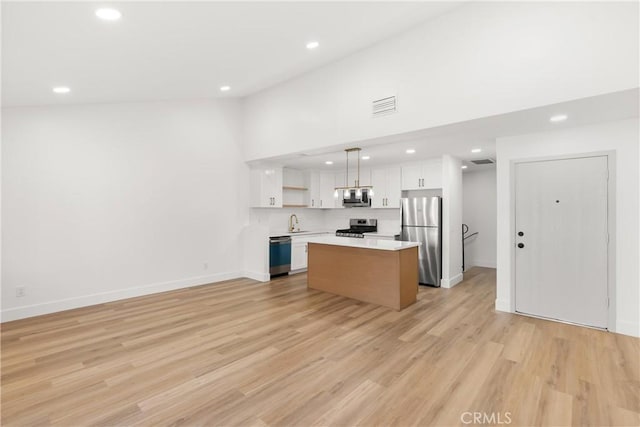 87 Tennessee St Unit C, Redlands, CA 92373 - kitchen with stainless steel appliances, open shelves, a sink, white cabinetry, and recessed lighting