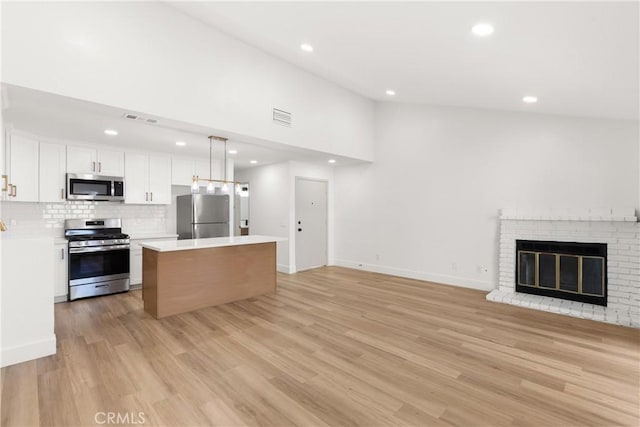 87 Tennessee St Unit C, Redlands, CA 92373 - kitchen featuring stainless steel appliances, open floor plan, a kitchen island, white cabinets, and light countertops
