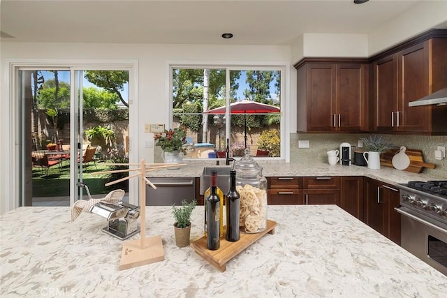 44 Edenbrook, Irvine, CA 92620 - kitchen featuring high end stainless steel range oven, light stone countertops, backsplash, and dark brown cabinets