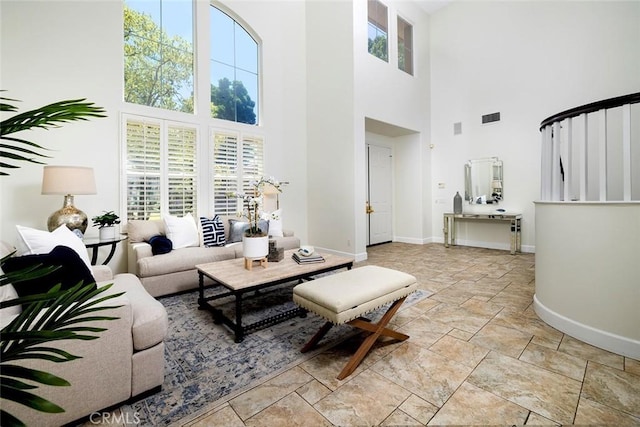 44 Edenbrook, Irvine, CA 92620 - living area featuring a high ceiling, visible vents, baseboards, and stone tile flooring