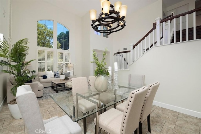 44 Edenbrook, Irvine, CA 92620 - dining room with a notable chandelier, a towering ceiling, baseboards, stairway, and stone tile floors