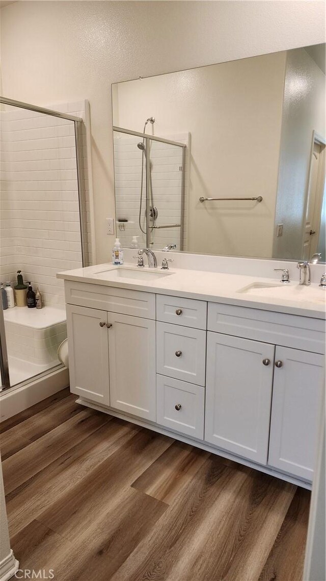30874 Windy Ridge Way, Menifee, CA 92584 - bathroom featuring a stall shower, double vanity, and wood finished floors