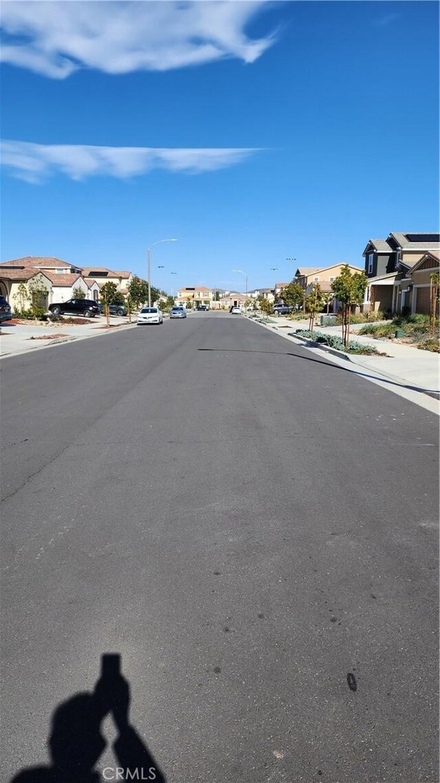 30874 Windy Ridge Way, Menifee, CA 92584 - view of asphalt road featuring a residential view, sidewalks, curbs, and street lighting