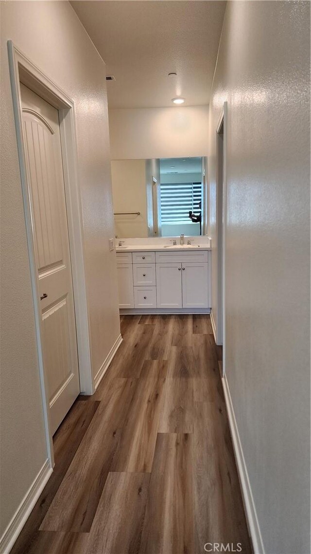 30874 Windy Ridge Way, Menifee, CA 92584 - hallway featuring dark wood-type flooring, baseboards, and a sink