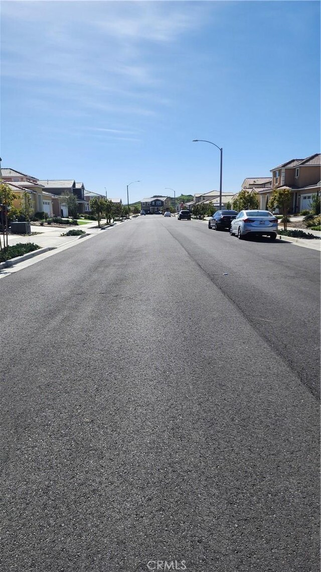 30874 Windy Ridge Way, Menifee, CA 92584 - view of asphalt road with sidewalks, street lighting, a residential view, and curbs