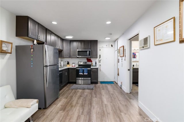 kitchen with baseboards, light countertops, backsplash, light wood-style floors, and stainless steel appliances