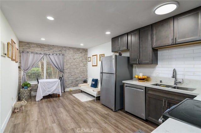 kitchen with a sink, light countertops, tasteful backsplash, and appliances with stainless steel finishes