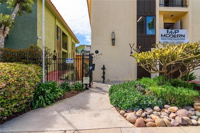 exterior space featuring fence, a gate, and stucco siding