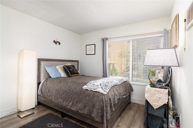 bedroom featuring baseboards and wood finished floors