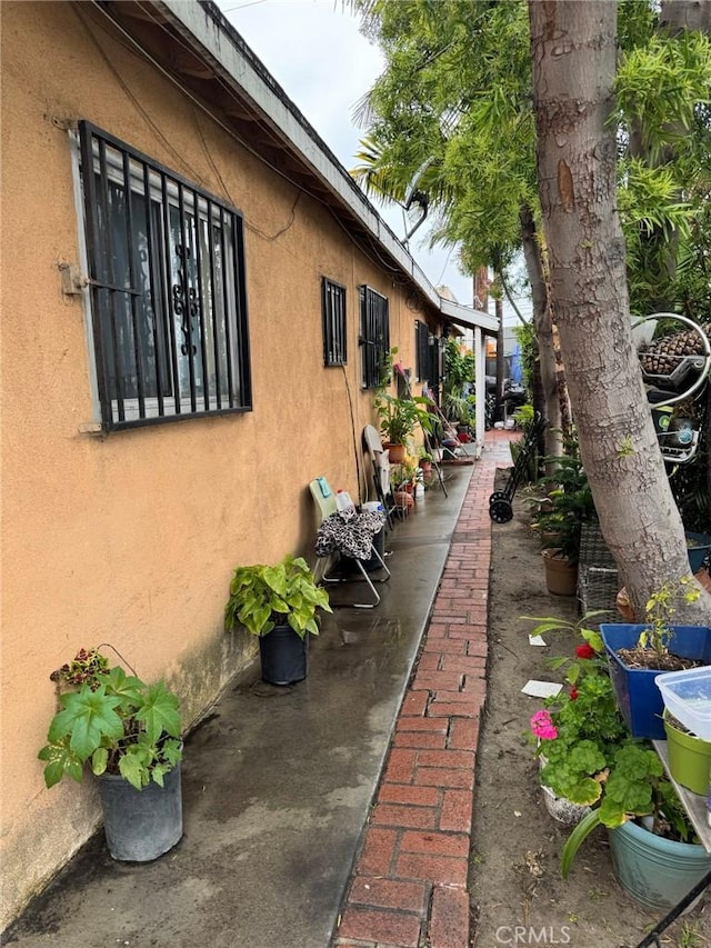 view of side of home featuring a patio area and stucco siding
