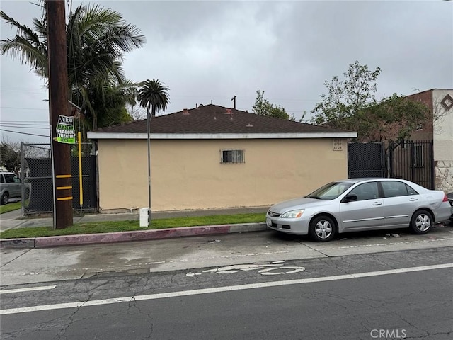view of property exterior featuring fence and stucco siding
